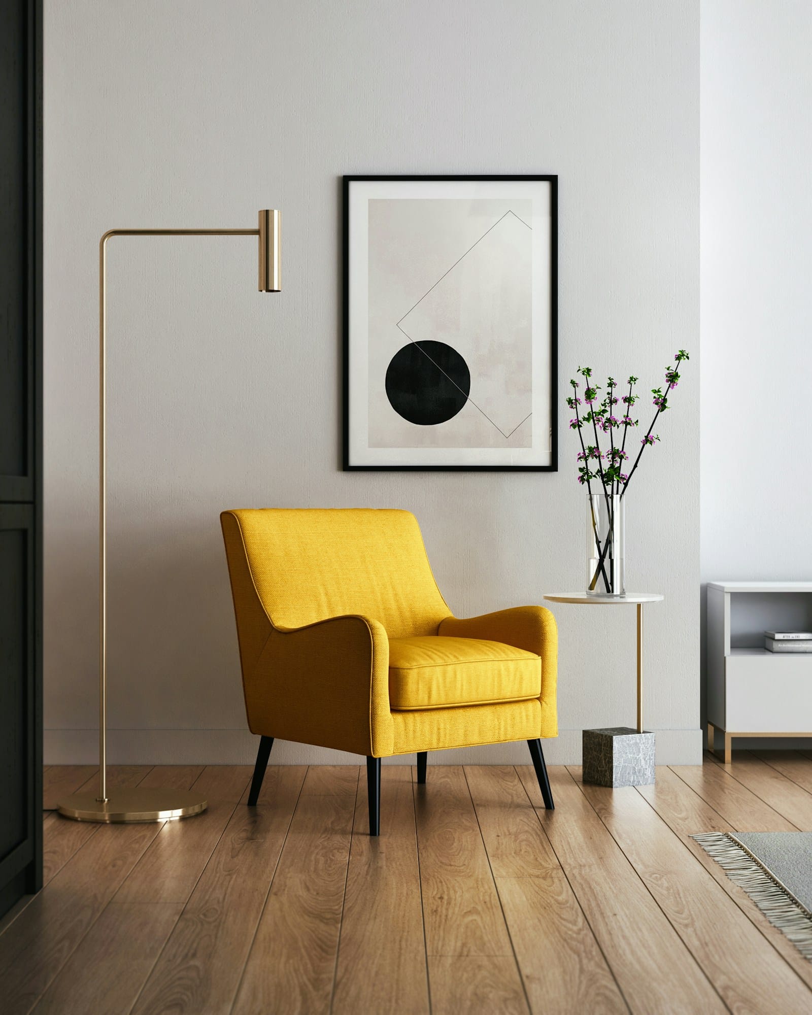 A quiet corner with a mustard armchair, brass floor lamp and a single framed print